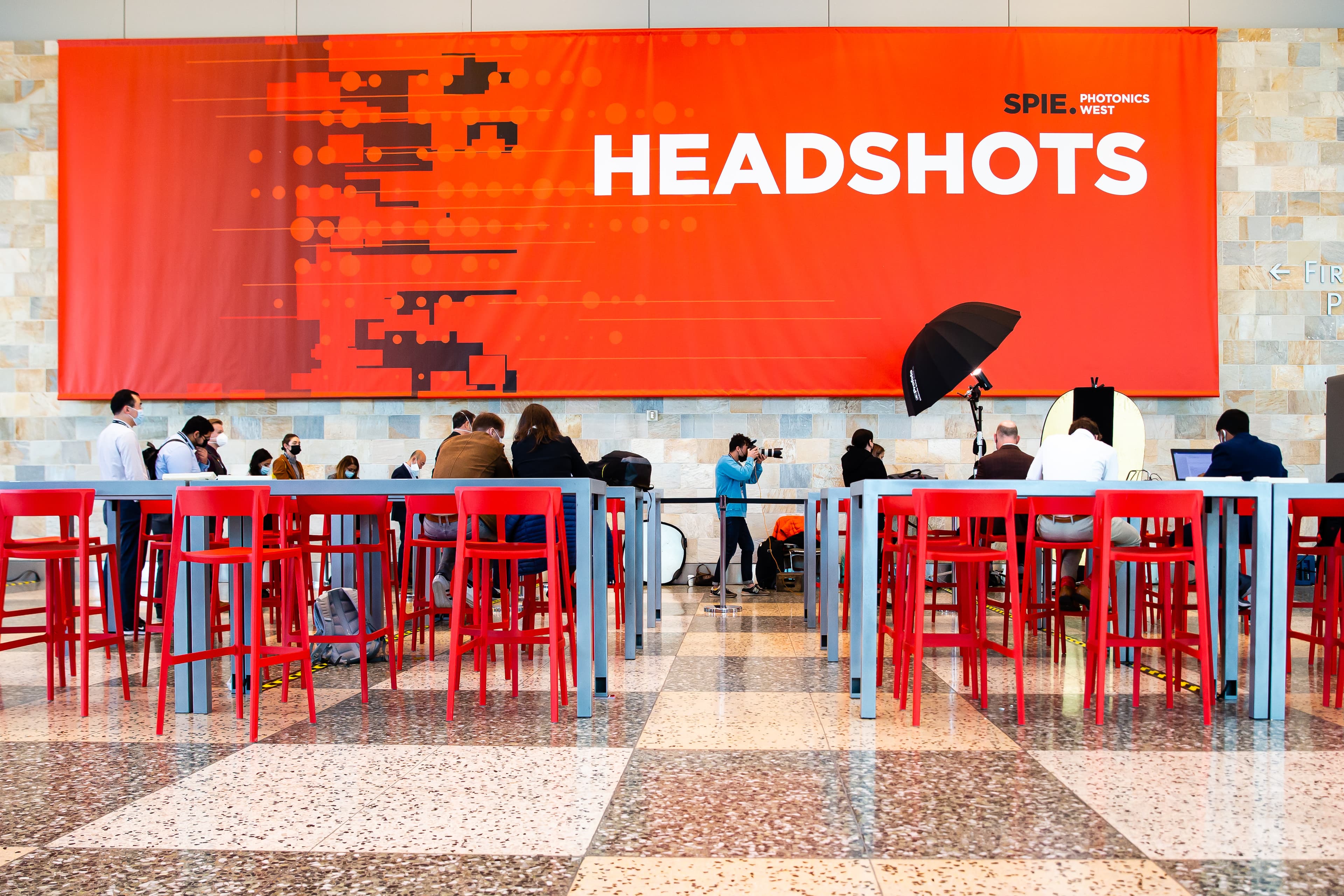 A Two Dudes Headshot Booth set up on a trade show floor, lights and backdrop in place